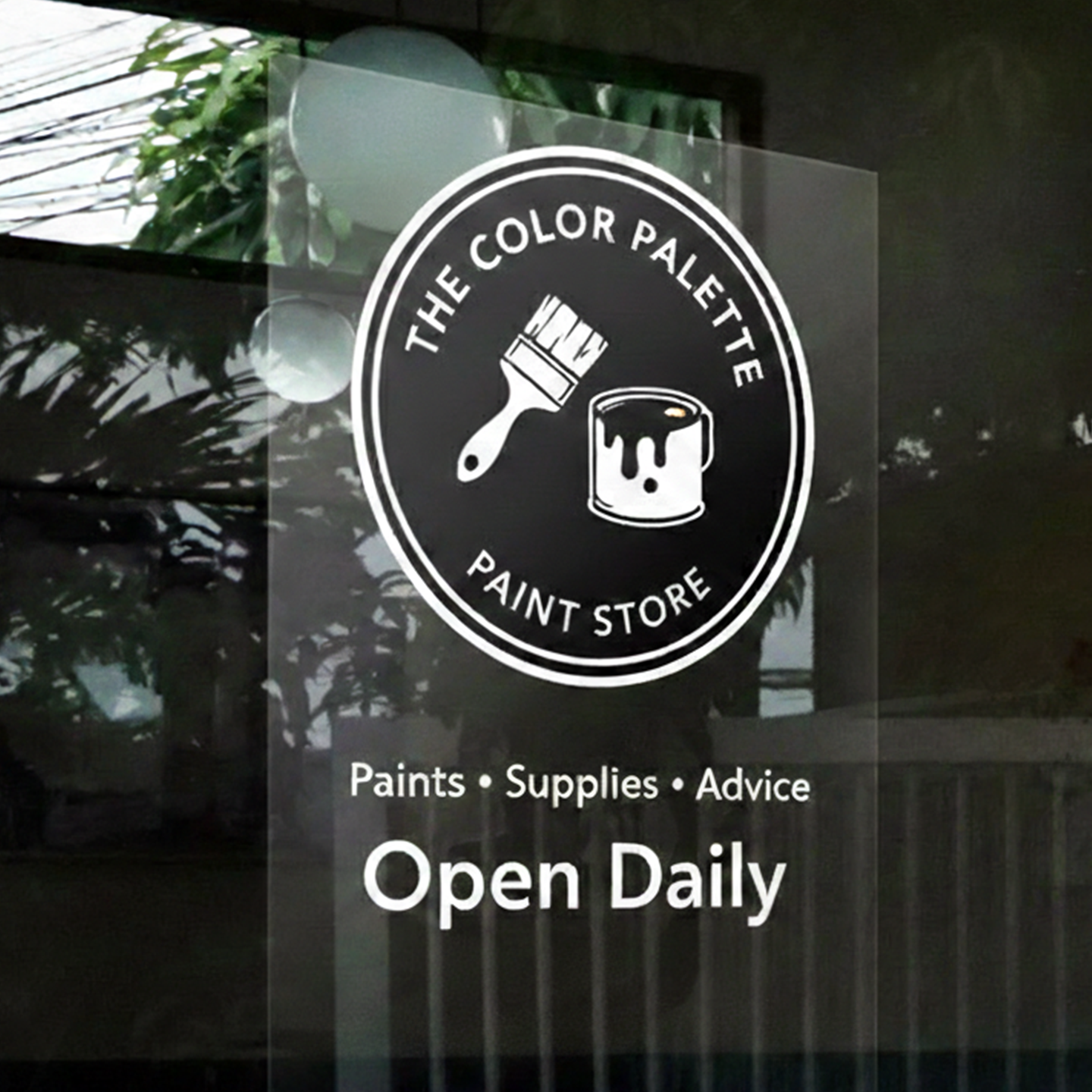 Window sign for The Color Palette Paint Store with outdoor reflection